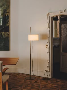 a living room with a lamp on the floor