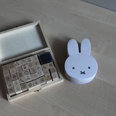 a wooden box with a calculator in it and a bunny face on the lid