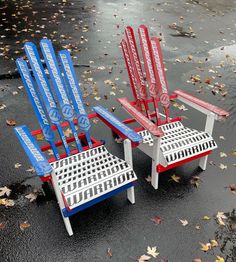 two red, white and blue lawn chairs sitting on top of a wet ground next to each other