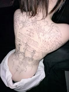 the back of a woman with tattoos on her body