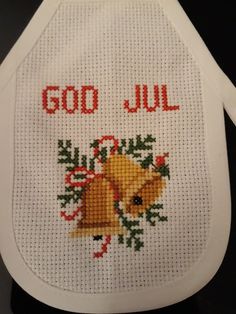 a cross stitched apron with the words god, july and a bell on it