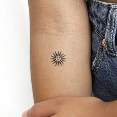 a woman's arm with a small tattoo on the left side of her arm