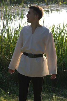 "Shop now Off white Viking tunic! Simple pagan shirt is made of pure soft cotton fabric and hand stitched. You can wear it with belt and hooded cloak or as a separate item.  Perfect for LARP events, viking festivals, renfaire events etc. See more medieval shirts here https://www.etsy.com/shop/EthnicandMedieval?ref=seller-platform-mcnav&section_id=35034405 The length is approximately 31.5 \" (80 cm) from top shoulder to hem. Available in any size. For custom orders please specify your measurement Viking Costume Tunic, Middle Ages Shirt, Medieval Clothing Shirts & Tops, Linen Viking Shirt, Viking Style Tunic For Larp, Peasant Style Medieval Dress For Larp, Peasant Style Medieval Dress With Long Sleeves, Renfaire Outfit, Peasant Clothing