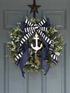 a wreath with an anchor and ribbon hanging on a door