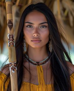 a woman with long black hair holding a wooden stick in her hand and wearing jewelry