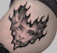 a woman's stomach with a tattoo design on the side and her face in flames