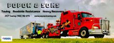 a red semi truck pulling a trailer behind it on top of a grass covered field