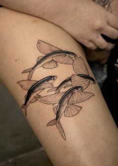 a woman's thigh with two fish on it