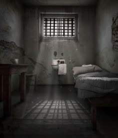 a dark room with a bed, sink and window on the wall next to it