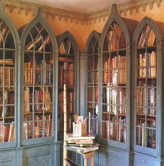 a room filled with lots of books on top of wooden shelves next to each other