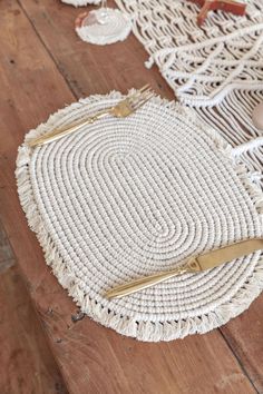 a white woven placemat with gold handles on a wooden floor next to other items