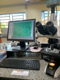 a microscope and computer monitor on a table