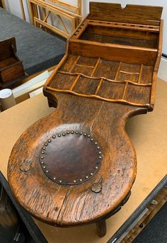 an old wooden chair that has been turned into a table with studded buttons on it