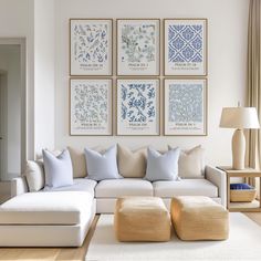 a living room with white furniture and blue artwork on the wall above the couches