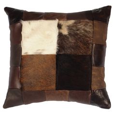 a brown and white patchwork pillow on a white background