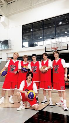 a group of young men standing next to each other holding basketballs