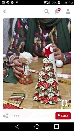 a woman sitting at a table with some christmas decorations on top of it and measuring tape around her