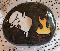 a rock with a drawing of a dog and fire on it