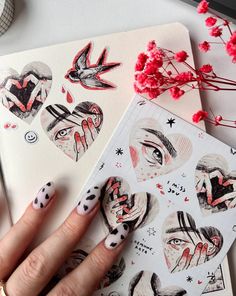 a woman's hand with black and white nail polish next to some stickers