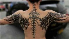 the back of a man with tattoos on his body