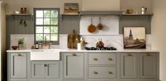 a kitchen with gray cabinets and white counter tops