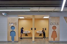 two people are standing in front of the boys'restrooms at the subway station