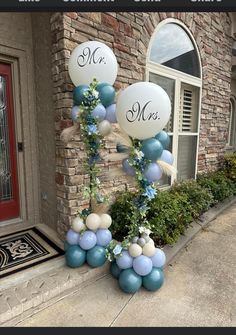 some balloons that are on the side of a building with blue, white and silver decorations