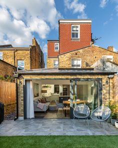 an outdoor living area with patio furniture and brick building in the background, on a sunny day