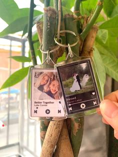 a person holding up a cell phone with a picture hanging from it's back