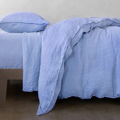 a bed with blue sheets and pillows on it