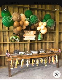 a table with some fish hanging from it's sides and balloons in the background