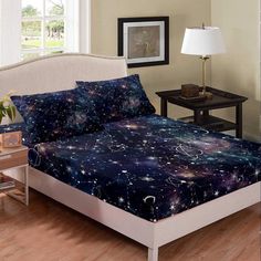 a bed room with a neatly made bed and a night sky comforter