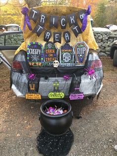 the trunk of a car decorated for halloween with decorations on it and a pot full of candy