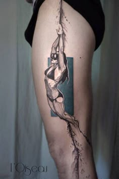 a woman's leg with a tattoo on it that has an image of a person hanging