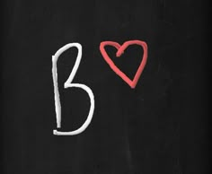 two hearts drawn on a blackboard next to the number thirteen with white chalk and red marker