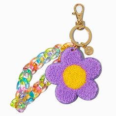 a crocheted key chain with a purple flower on the front and yellow center