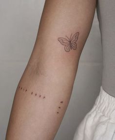 a woman's arm with a butterfly tattoo on the left side of her arm