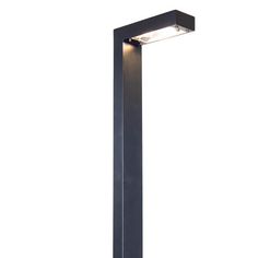 an outdoor light that is on the side of a pole with its lights turned on