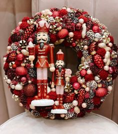 a christmas wreath with nutcrackers and other decorations on the front of it