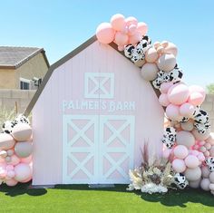 a pink barn decorated with balloons and flowers