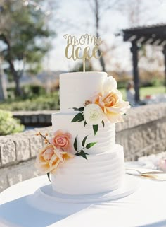 a white wedding cake with flowers on top