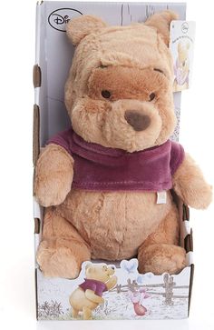 a brown teddy bear sitting in a cardboard box