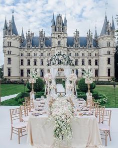 an instagram photo of a wedding in front of a castle with flowers on the table