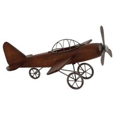 a wooden model airplane with wheels on it's sides and a propeller attached to the wing