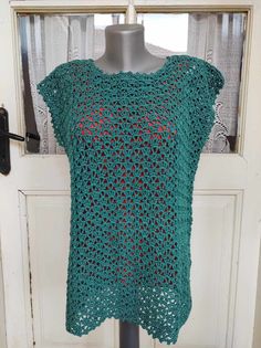 a green crocheted top on a mannequin