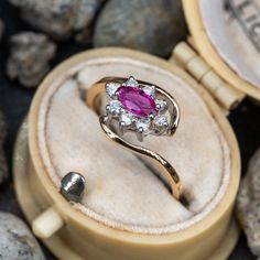 This pretty ring is centered with one (1) marquise cut ruby set into a four-prong setting. The ruby is bordered with eight (8), prong set, round brilliant cut diamonds. The ring measures 9.4mm at the top, rises 5.5mm above the finger, tapering to 1.8mm wide and 1.3mm thick at the base of the shank. This ring is currently a size 5.25. Vintage Ruby Rings, Ruby Ring Vintage, Pink Topaz Ring, Ruby Set, Ruby Rings, Pretty Ring, Pink Sapphire Ring, Ruby Engagement Ring, Aquamarine Jewelry