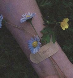 a person's foot with flowers on it and a piece of paper taped to the ankle