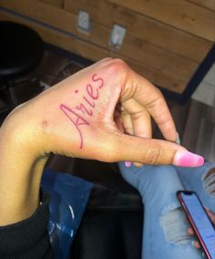 a woman's hand with the word alive written on it and a cell phone next to her