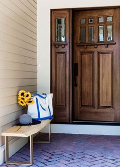 a sunflower sitting on a bench in front of a door