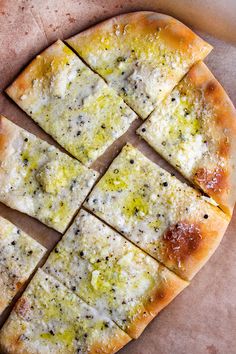 a sliced pizza sitting on top of a wooden cutting board